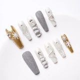 Close-up showing detailed, shiny nails with intricate jewellery and vibrant colors