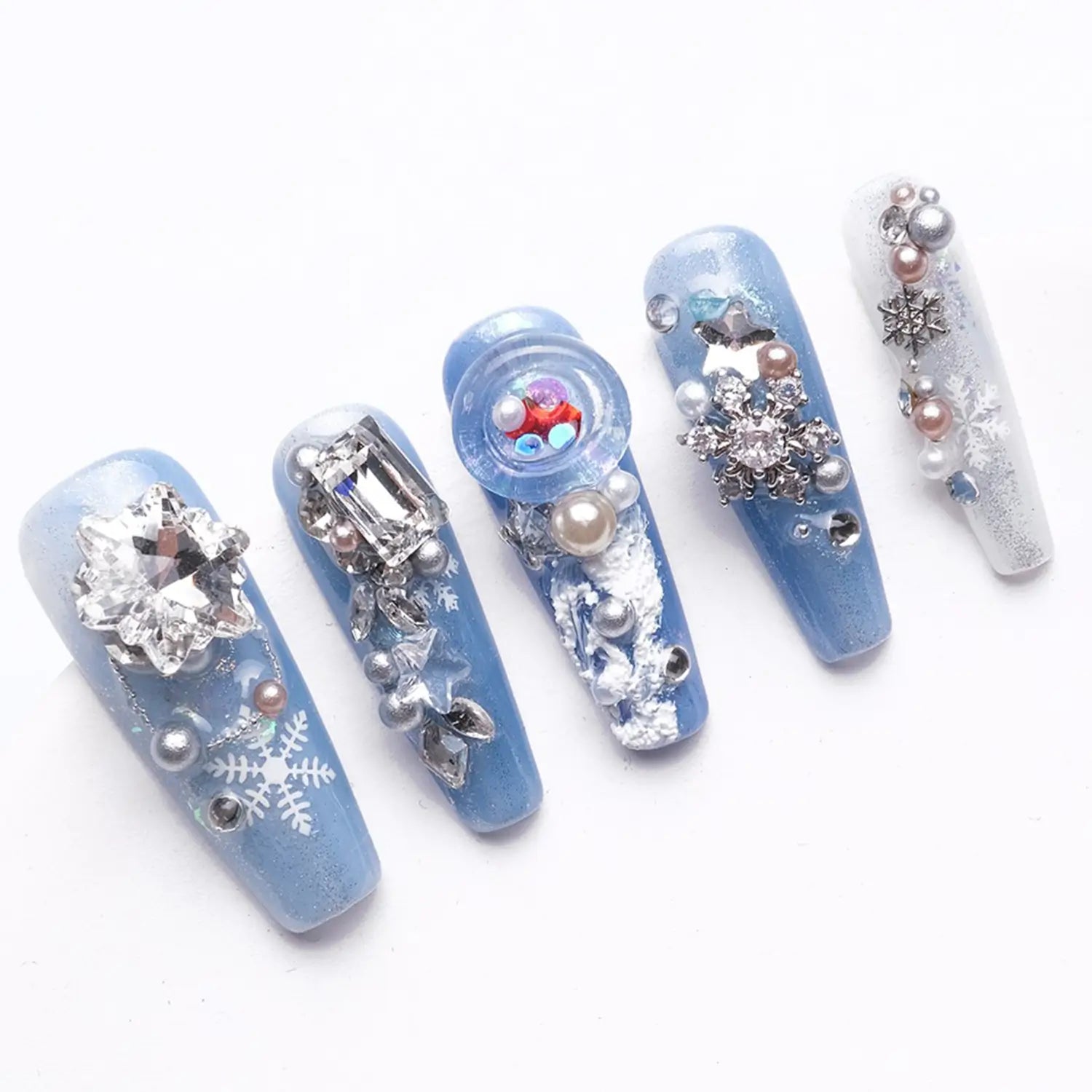 Each nail is adorned with various elements like rhinestones, pearls, snowflakes, and chains, adding a touch of sparkle and sophistication.
