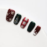 Close-up showing detailed, shiny manicure with intricate decorations and vibrant red and green colors