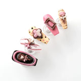 The colors are mainly pink, black and beige, dotted with lollipop-shaped press-on nails