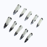 Press-on nails with black spots on the milky white base