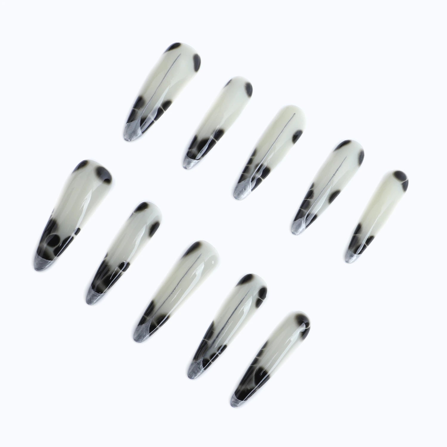 Press-on nails with black spots on the milky white base