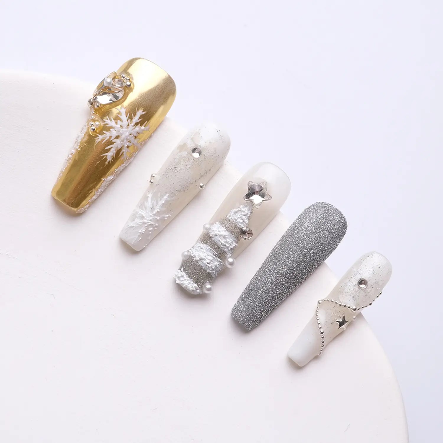 Press on nails are mainly gold, white and silver, dotted with snowflakes and Christmas tree shapes