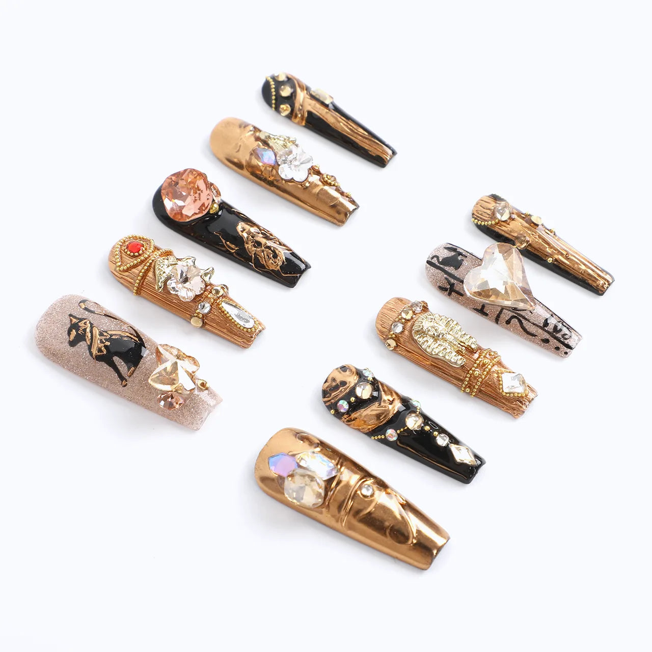 The nails feature a luxurious gold base and black and are embellished with an assortment of rhinestones