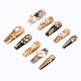 A side view of press-on nails, creating a mysterious and opulent Egyptian-inspired design.