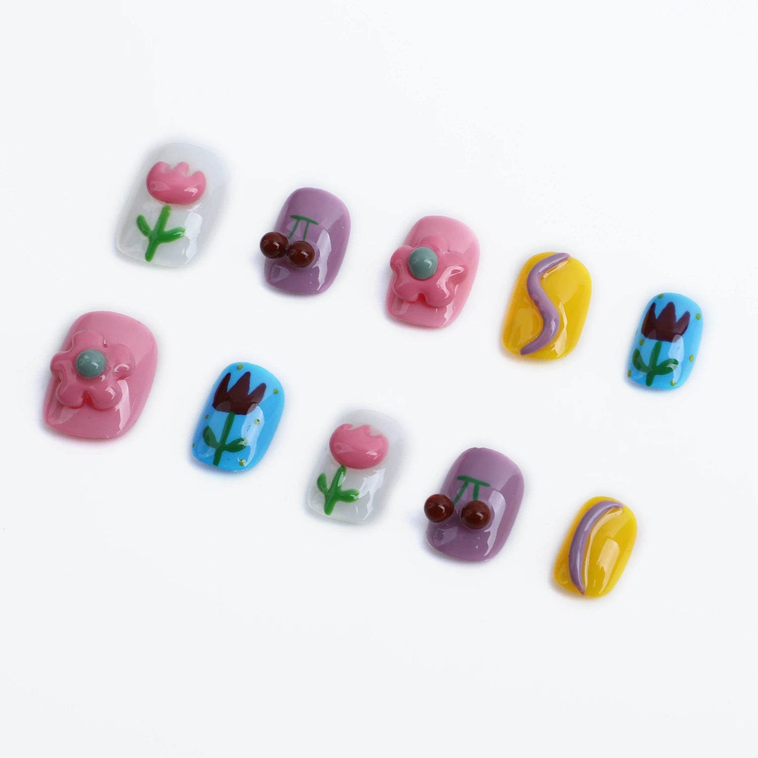 Press-on nails in soft pink, purple and blue with vibrant designs